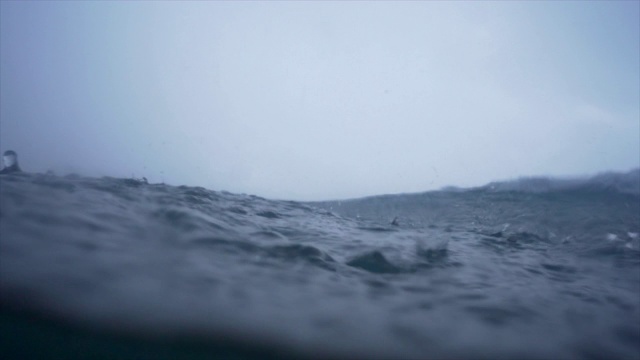 水下视图的雨击中海洋和海浪海浪。——慢动作视频下载