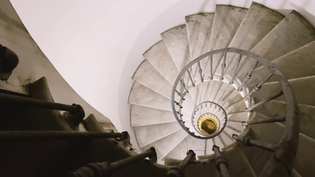 从一个有铁扶手和大理石台阶的古老旋转楼梯的顶端望出去视频素材