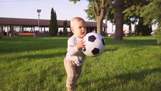 兴高采烈的孩子手里拿着球在公园里散步。慢动作视频素材