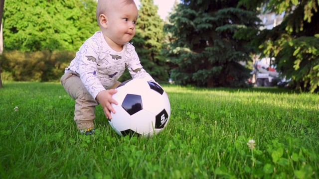 兴高采烈的孩子手里拿着球在公园里散步。慢动作视频素材