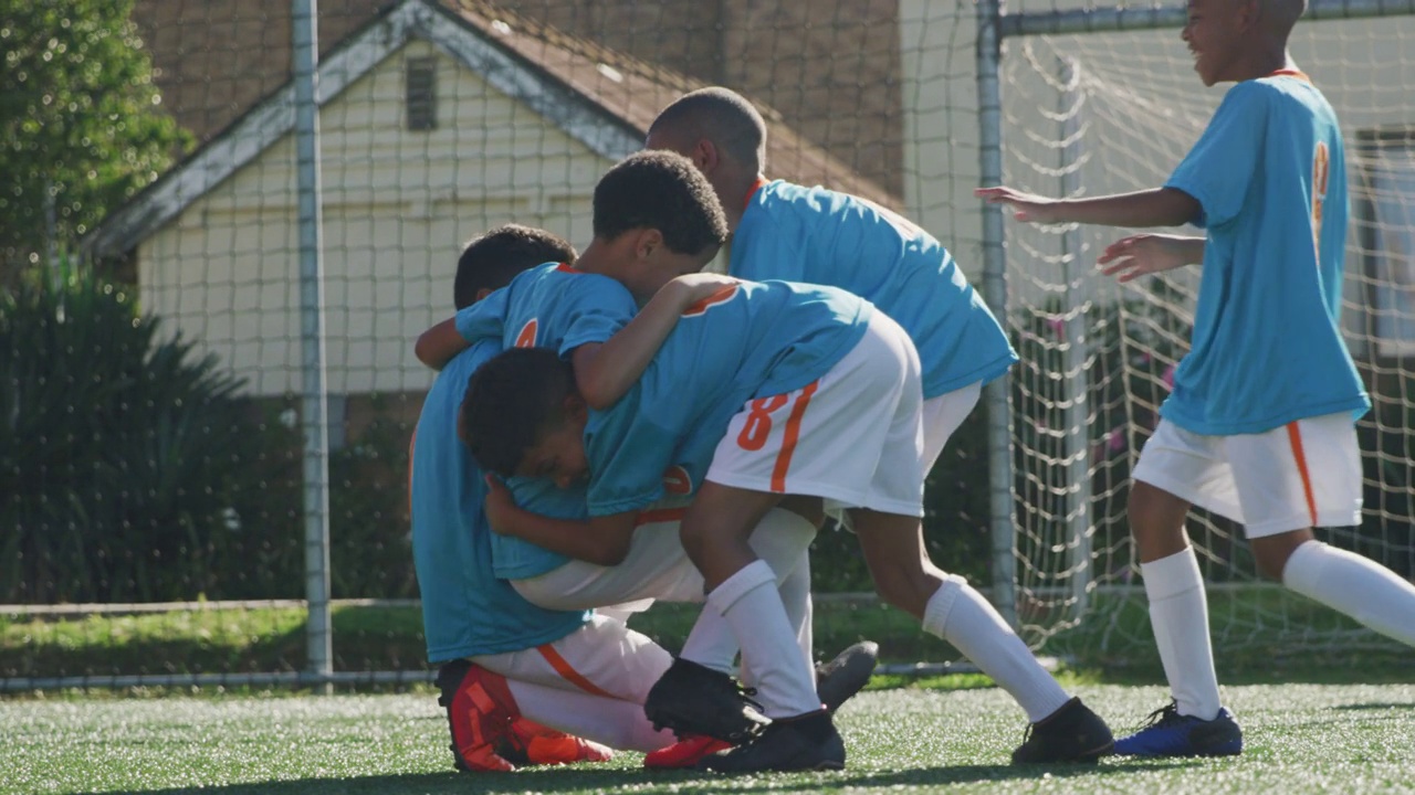 足球的孩子们在蓝色的微笑，在阳光明媚的日子里欢呼视频下载
