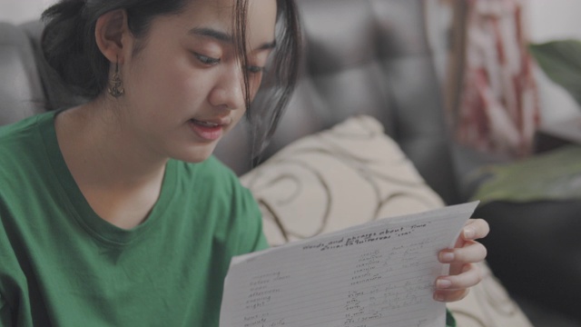 特写和手持拍摄迷人的亚洲少女使用笔记本电脑视频会议与她的同学头脑风暴关于他们的演示项目。在冠状病毒或冠状病毒19封锁期间，在线家庭学校。视频通话技术。视频下载