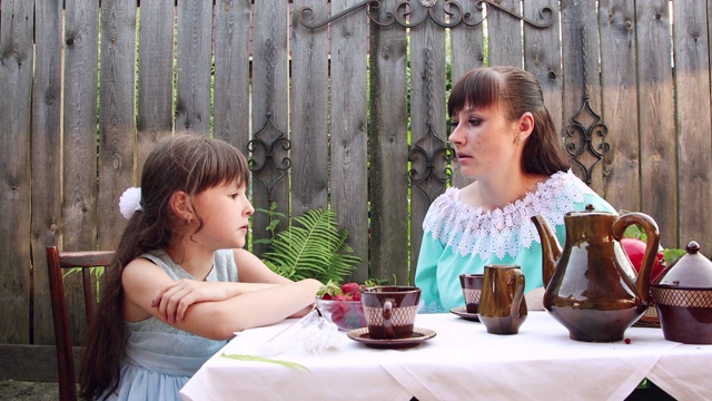 女孩和她的母亲正坐在桌子旁愉快地交谈。视频素材