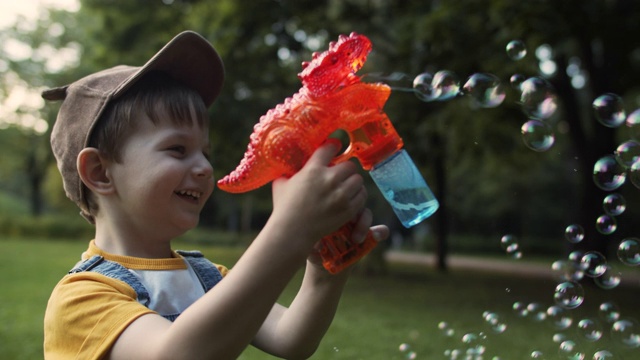 小男孩在夏日公园吹肥皂泡视频素材