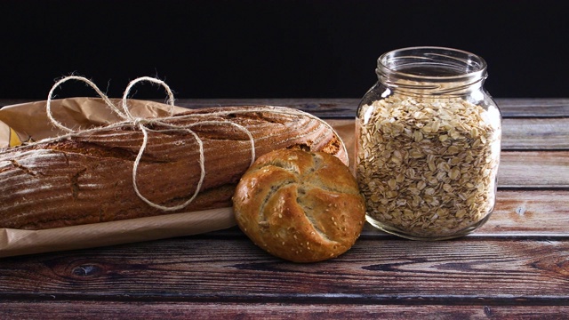 黑麦有机面包，烘焙产品和燕麦瓶在桌子上。早餐和健康饮食的概念视频素材