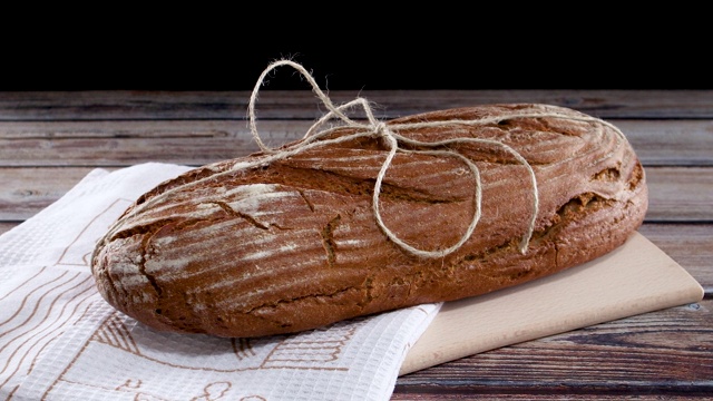 黑麦有机健康面包切板和布在木桌上视频素材