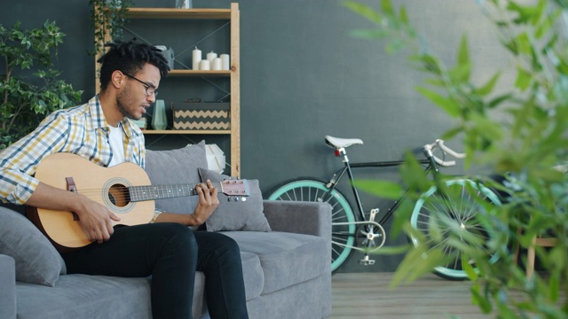 富有创造力的非裔美国人在闲暇时间在家弹吉他和唱歌视频素材