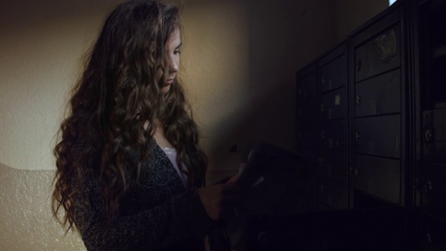 一个年轻的白人女人在检查家里的邮箱。视频素材
