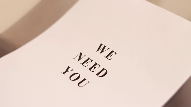 “我们需要你”这个短语被印在一张纸上视频下载