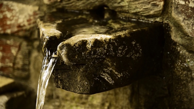 新鲜的矿泉水在森林石水龙头中流动。视频素材