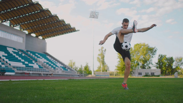 职业男子足球运动员运动员在足球场上用慢动作在运动器材上弹起足球视频素材