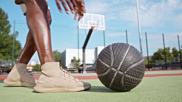 一个黑人拿着篮球并运球到篮筐的特写镜头视频下载