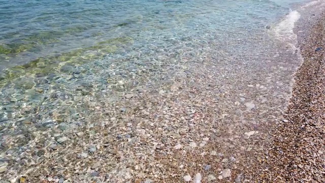 小海浪拍打着沙滩上的鹅卵石视频素材