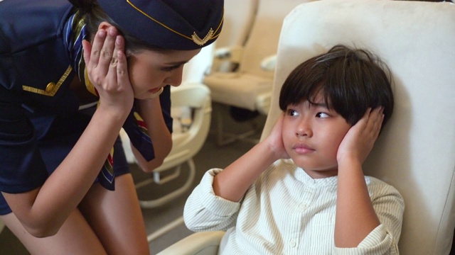 空乘人员建议哭泣的男孩在飞行中捂住耳朵视频下载