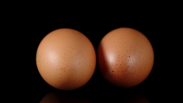两个生鸡蛋在桌子上慢慢旋转。视频下载