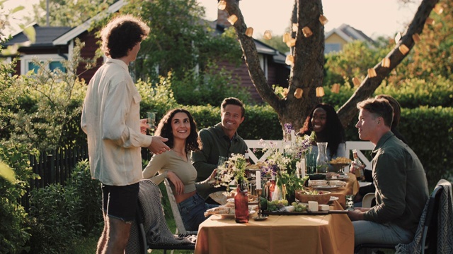 手持拍摄的男人与朋友交谈，而站在桌旁的花园派对视频下载