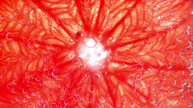 将新鲜成熟的葡萄柚切片，浸泡在带有气泡的水中。视频下载