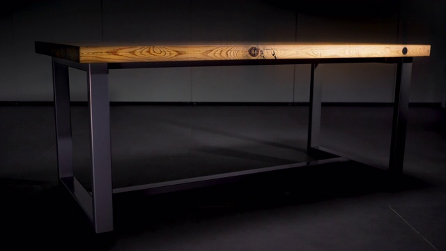 黑色背景上的木桌。资料片。近距离的木桌与黑色的铁腿站在空房间在黑暗变化的光视频下载