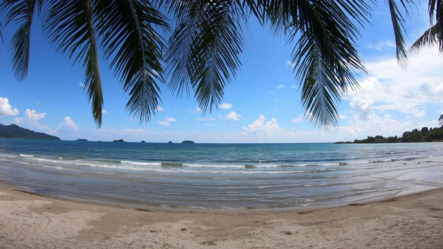 清澈的大海和白色的沙滩，椰子树和天空为背景，在泰国特拉特Koh Chang。视频素材