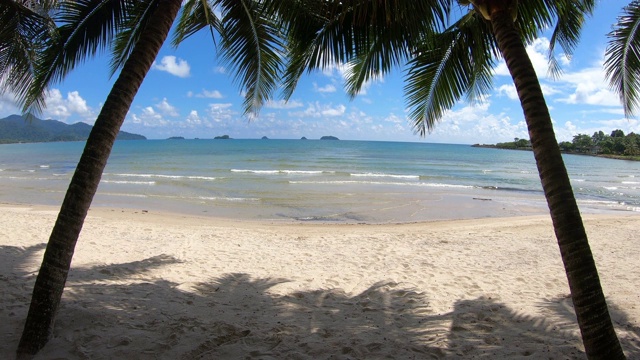 清澈的大海和白色的沙滩，椰子树和天空为背景，在泰国特拉特Koh Chang。视频素材