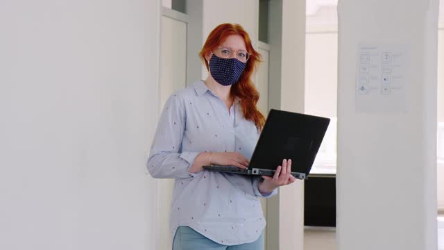 一个在办公室里用笔记本电脑的女商人的肖像视频素材
