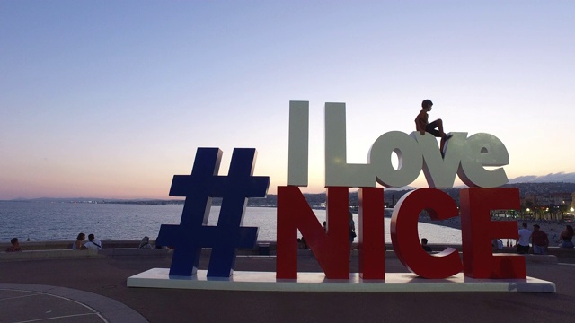 一个男孩站在一个写着“我爱Nice”的牌子上视频下载