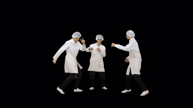 三个穿着白袍戴着防护帽的男医生在阿尔法频道跳着有趣的庆祝舞视频素材