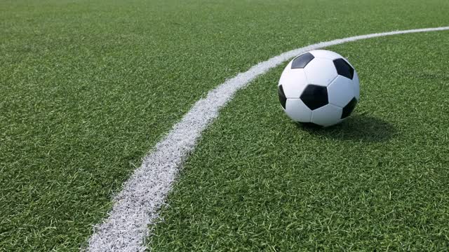 足球运动员用脚在绿色足球场的角线上击球的慢动作。足球运动员把球传给队友。在一个大型体育场举行的足球比赛。体育运动视频素材