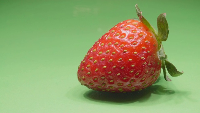 草莓特写。成熟的有机水果。绿色背景上的浆果。4 k的视频。视频下载