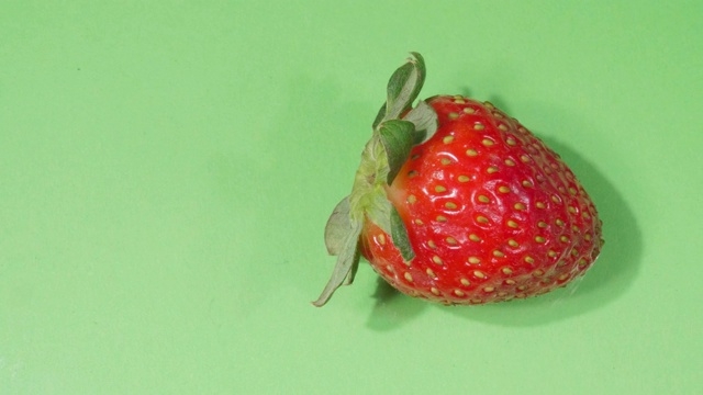 草莓特写。成熟的浆果。4 k的视频。绿色背景。视频下载