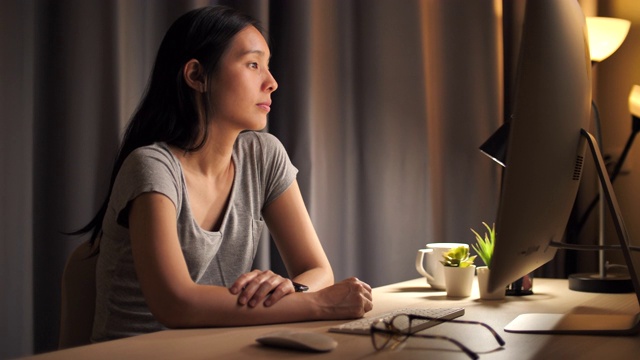 亚洲妇女使用电脑在晚上看电脑显示器视频素材
