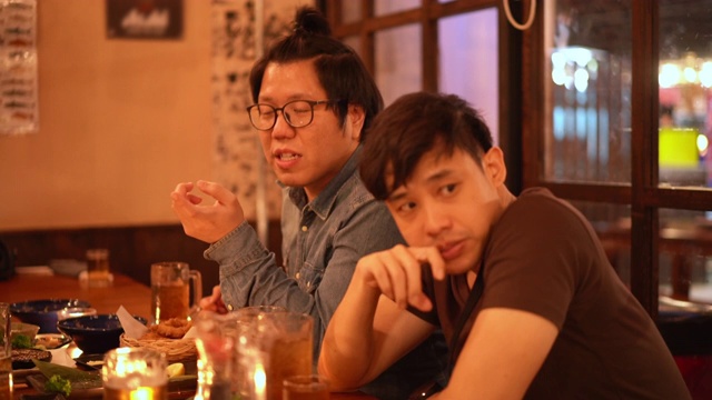三杯两亚洲男人在居酒屋日本酒吧餐厅喝酒聊天视频素材