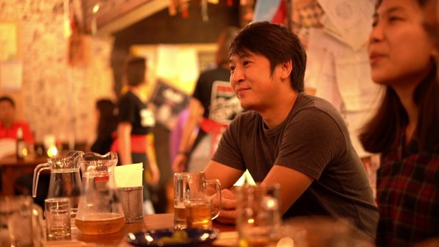 亚洲男子喜欢在居酒屋酒吧喝酒和听他的朋友开玩笑视频下载