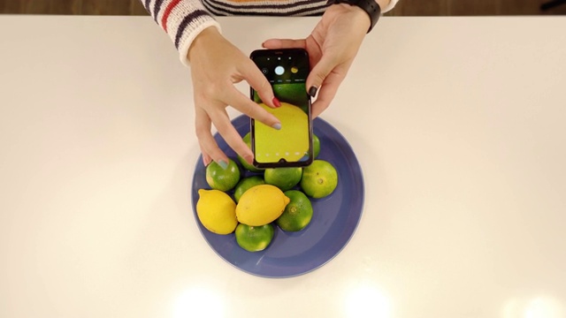 修指甲的女人用智能手机拍水果照片视频下载