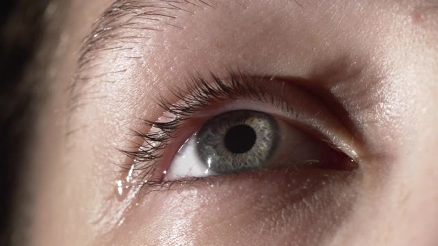 特写镜头的女孩与泪水在灰色的眼睛视频下载