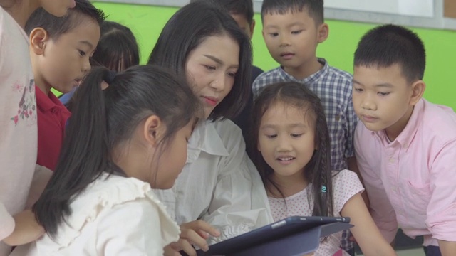 幼兒園老師用平板電腦給她的學生看，所有的孩子看起來都很專注和感興趣視頻素材