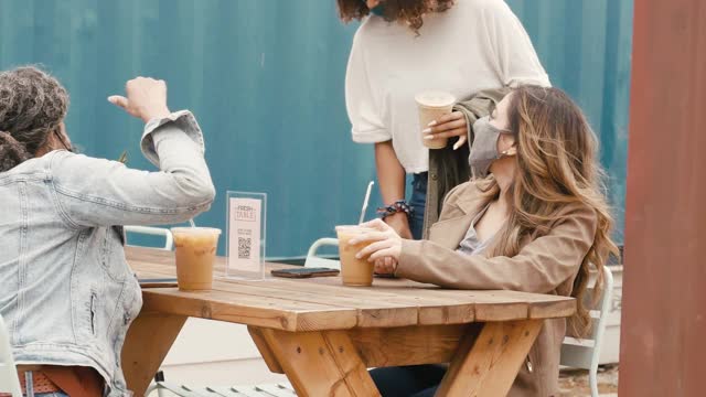 三个女性朋友在户外咖啡馆见面喝咖啡视频下载