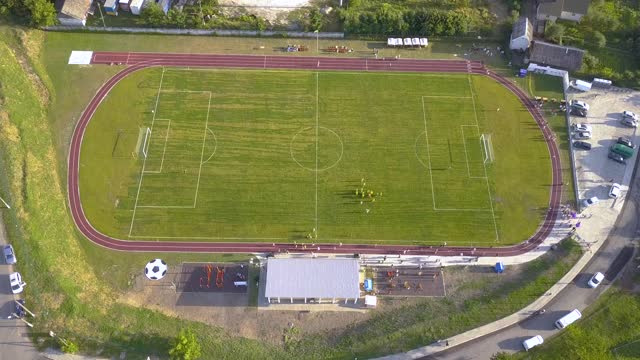 鸟瞰图上的足球场覆盖着绿色的草地在农村城镇地区。视频素材