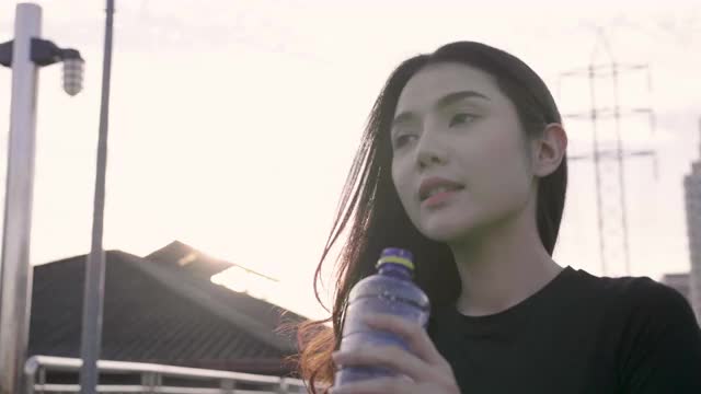 亚洲健身妇女在跑步后喝水视频下载