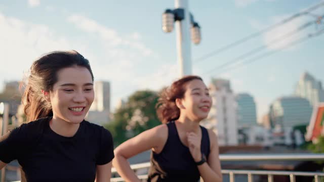 兩名亞洲女性在公園邊慢跑邊看她的智能手表視頻素材
