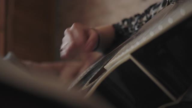 弹吉它弦的女音乐家。视频下载