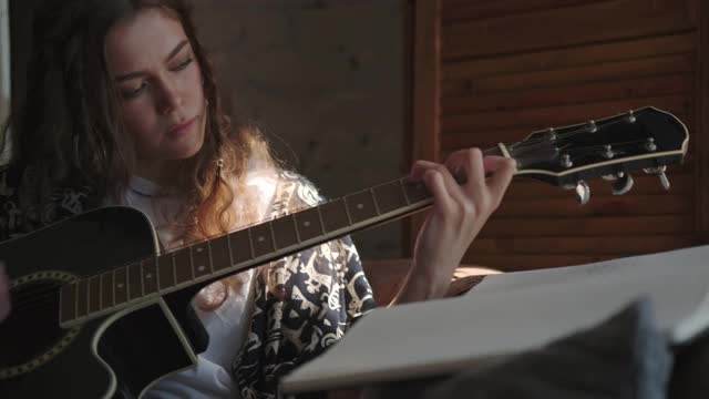 富有创造力的女人用吉他弹奏和作曲视频下载