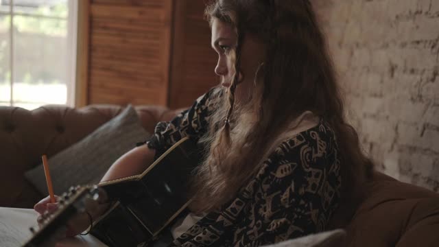有创造力的女音乐家用吉他独自写歌，作曲视频下载