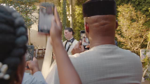 新婚夫妇的客人们聚在一起用手机拍照视频素材