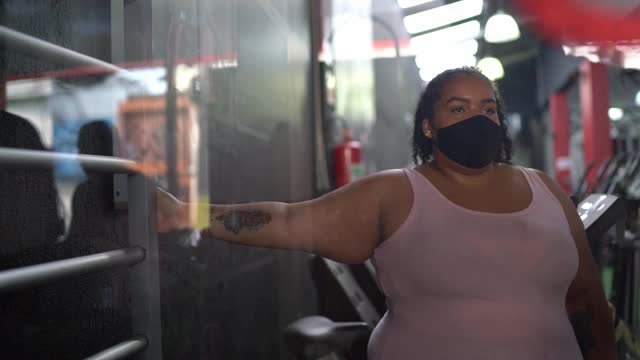 年轻女子在健身房用面罩拉伸视频素材