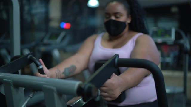 年轻女子在健身房用口罩做运动视频素材