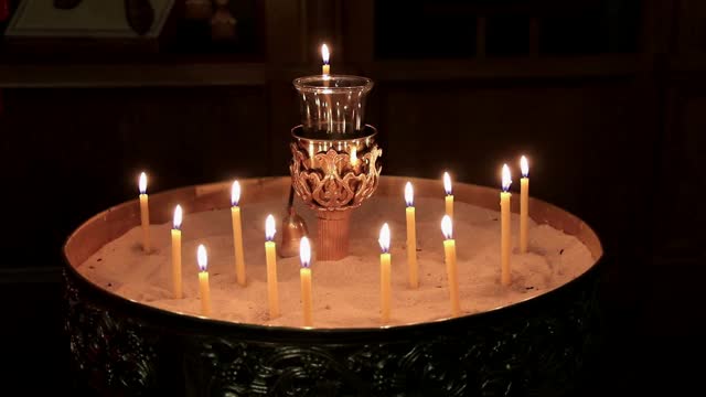 蜂蜡蜡烛在烛台蜡烛在沙华丽的黄铜持有人视频素材