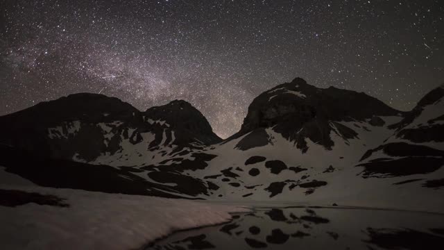 美丽的银河时光流逝在冰雪覆盖的艾尔高山脉和一个冰湖视频素材