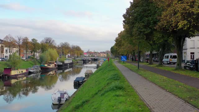 Aerial, pov，一条树木环绕的运河，在一个阳光明媚的日子，Gent，比利时视频素材