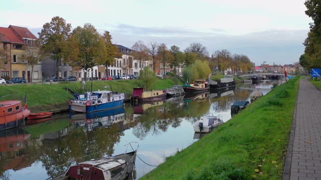Aerial, pov，一条树木环绕的运河，在一个阳光明媚的日子，Gent，比利时视频素材